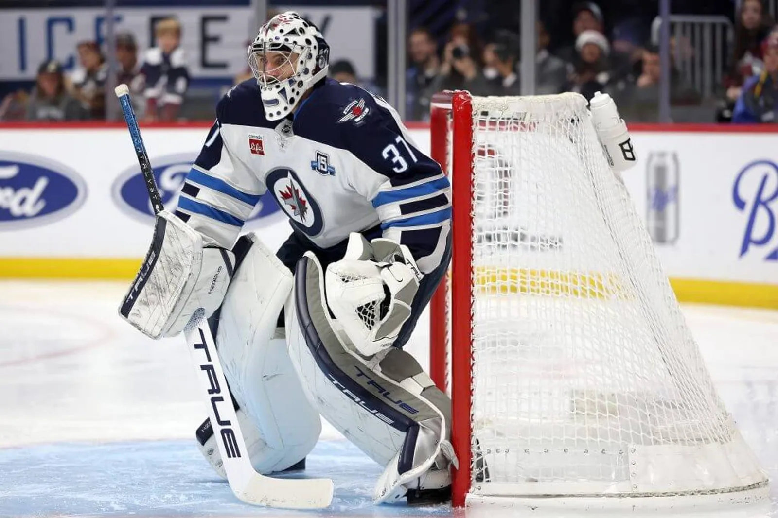 Connor Hellebuyck crouches slightly in the net while squaring up to a shot during a Jets game.