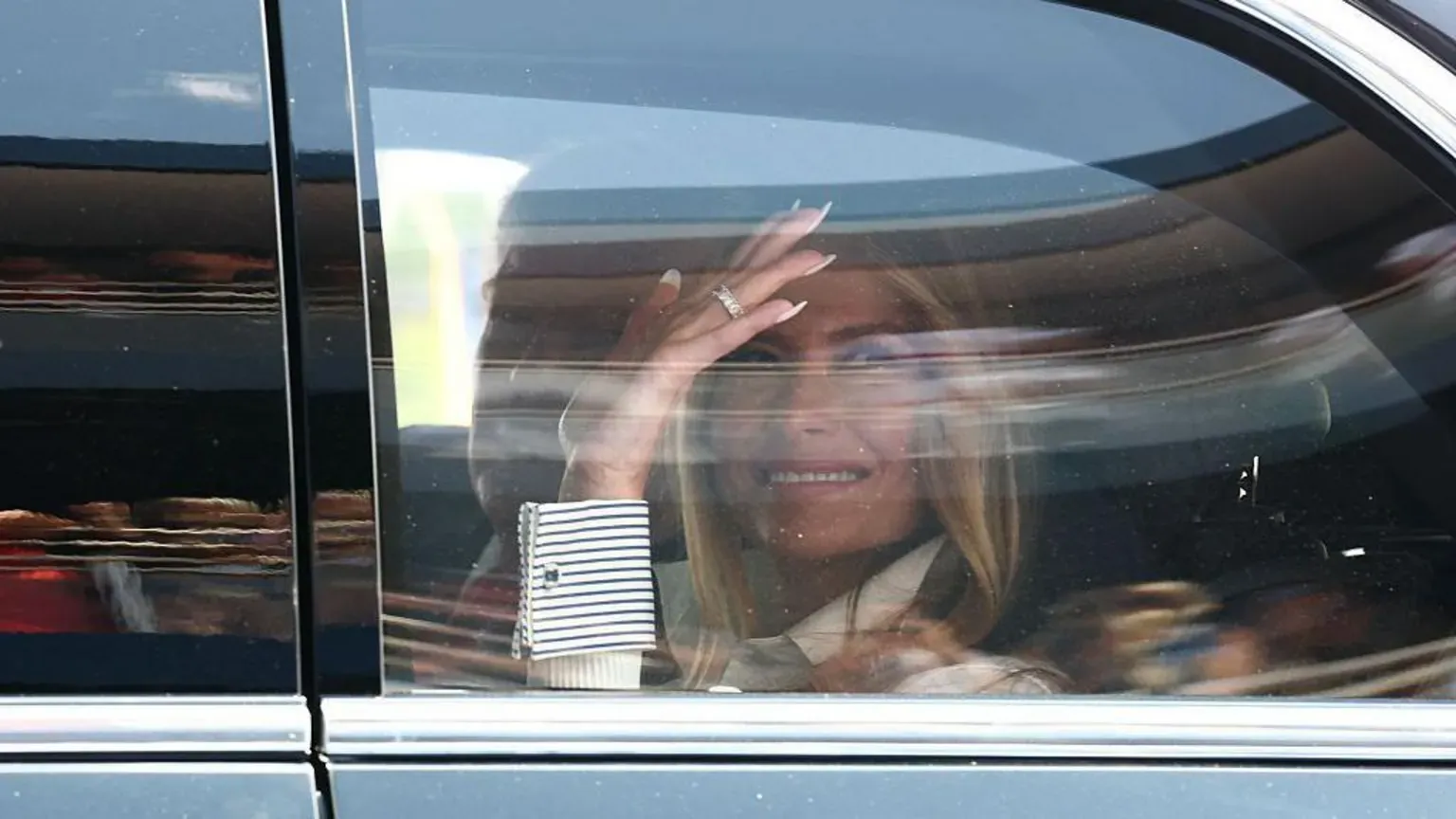 Getty Images Melania Trump waves in a car