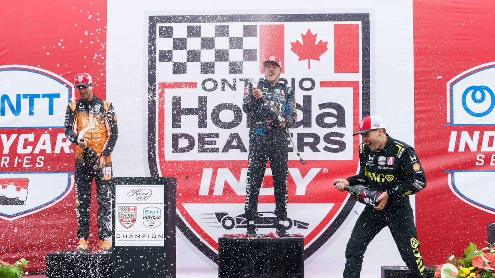 Marcus Ericsson, of Sweden, centre, celebrates after winning the 2026 Honda Indy with second-place Romain Grosjean, of Switzerland, left, and third-place Will Power, of Australia in Markham, Ont. on Sunday, Aug. 16, 2026. THE CANADIAN PRESS/Keito Newman