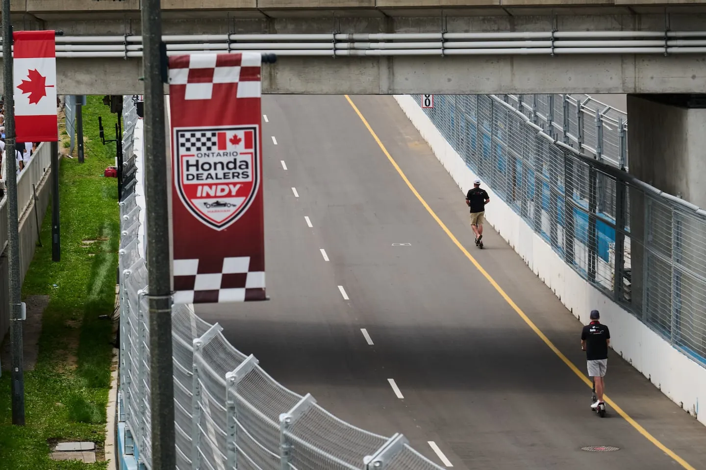 Honda IndyRace personnel scooter along empty racetracks as preparations continue ahead of the 2026 Honda Indy in Markham, Ont., Friday, Aug. 14, 2026. THE CANADIAN PRESS/Sammy Kogan