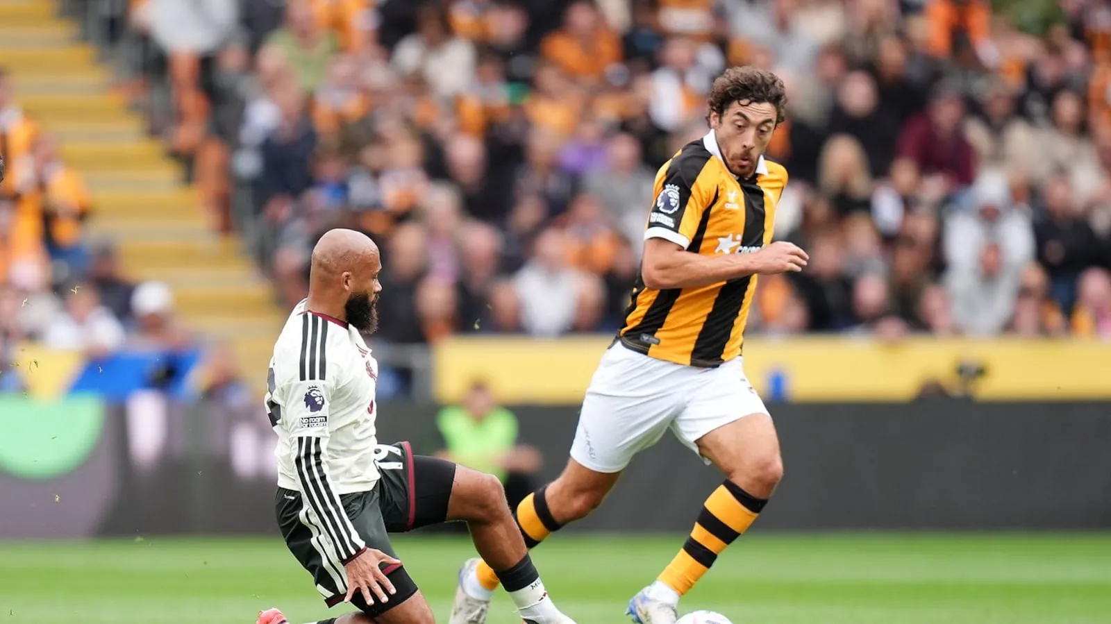 Manchester United's Bryan Mbeumo, left, and Hull City's Matt Crooks in action during the English Premier League soccer match between Hull City and Manchester United in Kingston upon Hull, England, Saturday Aug. 22, 2026. (Annabel Lee-Ellis/PA via AP)(Annabel Lee-ellis)