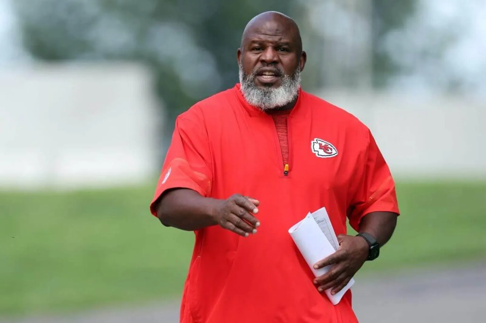 Chiefs offensive coordinator Eric Bieniemy walks toward the practice field at training camp.